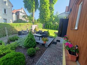 ein Hinterhof mit einer gemauerten Terrasse mit Möbeln und Pflanzen in der Unterkunft Apartament pod lipami in Jedlina-Zdrój + 4 Fotos