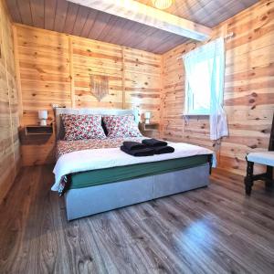 una camera con un letto in una baita di tronchi di Siedlisko przy lesie Musiejówka 