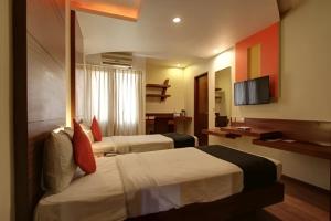 にあるStay Retreats At Hotel Destiny Nagpur - Near Airportのベッド2台とテレビがあるホテルの部屋
