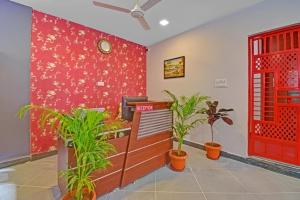 にあるStay Retreats At Hotel Destiny Nagpur - Near Airportの赤い壁と植物のあるオフィス