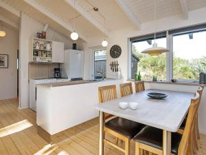 a kitchen and dining room with a table and chairs at Tranquil Haven in Nr Lyngby-By Traum in Løkken +13 photos