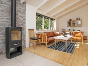 a living room with a fireplace and a couch at Tranquil Haven in Nr Lyngby-By Traum in Løkken