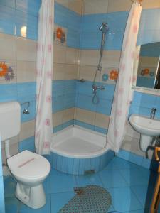 een badkamer met een bad, een toilet en een wastafel bij Pensiunea Cora in Piteşti