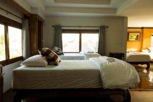 a bedroom with two beds and a window at จงเจริญเฮ้าส์ Jongcharoen's house  +1 photo