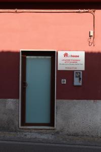 una puerta en el lateral de un edificio con una señal en Ali House en Montecorvino Rovella