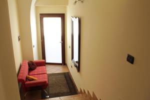 a living room with a red chair and a door at Ali House in Montecorvino Rovella