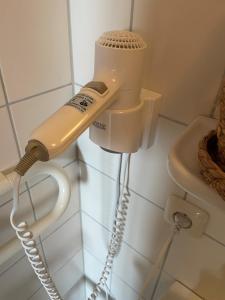 asciugacapelli appeso a un muro in bagno di LANDGASTHAUS Döbraberg a Schwarzenbach am Wald Altre 31 foto