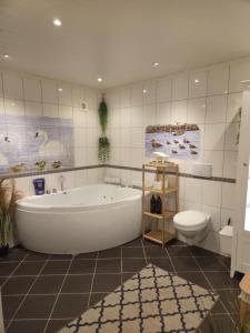 Un baño blanco con bañera y inodoro. en Senja Villa - Hot tub and northern lights view,  57 fotos más