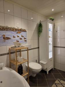 Un baño con inodoro y un cuadro en la pared. en Large house with a fantastic view at Senja, 