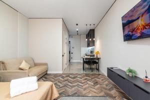 a living room with a couch and a table at Квартира в стиле лофт in Almaty