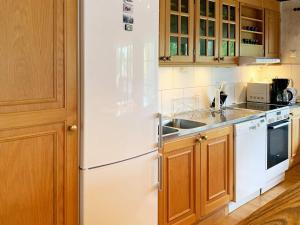 a kitchen with a white refrigerator and wooden cabinets at 4 person holiday home in Holsljunga in Holsljunga