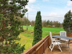 a wooden deck with a table and chairs on it at 4 person holiday home in Holsljunga in Holsljunga