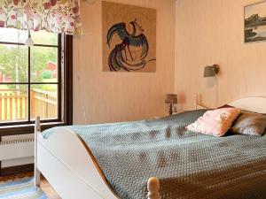 a bedroom with a bed with a chicken picture on the wall at 4 person holiday home in Holsljunga in Holsljunga