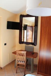 Montecorvino RovellaにあるAli Houseのテーブルと鏡付きの部屋