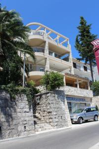 a building with a car parked in front of it at Swiss Residence Montenegro in Herceg-Novi