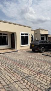 a black car parked in front of a house at Abode of peace Airport stay in Dar es Salaam