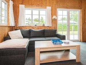 a living room with a couch and a coffee table at Tranquil Cottage near Kvie Lake-By Traum in Ansager