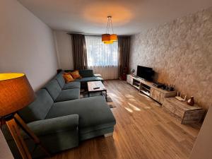 a living room with a couch and a tv at Apartment with a view of nature in Prievidza