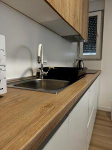 a kitchen with a sink and a wooden counter top at Apartman SLAVONIA 4 in Đakovo