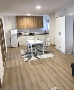 a kitchen with a white table and chairs in a room at Apartman SLAVONIA 4 in Đakovo