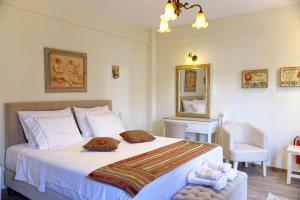 a bedroom with a large white bed with towels on it at Alexandra Hotel in Kalentzi