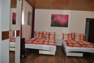 Cette chambre comprend deux lits et un canapé. dans l'établissement FeWo Grunig, à Lahr/Schwarzwald