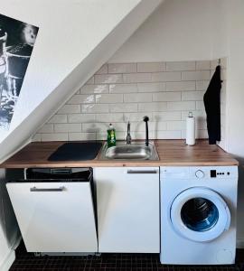 a kitchen with a sink and a washing machine at Charmante Maisonettewohnung im Herzen von Krefeld in Krefeld