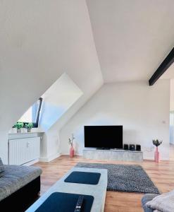 a living room with a flat screen tv in a attic at Charmante Maisonettewohnung im Herzen von Krefeld in Krefeld