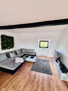 ein großes Wohnzimmer mit Couch und Fenster in der Unterkunft 116 m2 Charmante Maisonettewohnung im Herzen von Krefeld in Krefeld