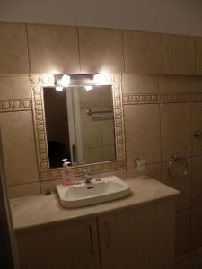 La salle de bains est pourvue d'un lavabo et d'un miroir. dans l'établissement Kate Apartments, à Kokkari