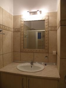 a bathroom with a sink and a mirror at Kate Apartments in Kokkari