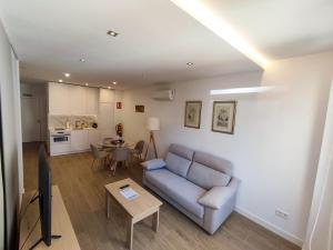 un soggiorno con un divano e un tavolo di Apartamentos BONDELA a Madrid