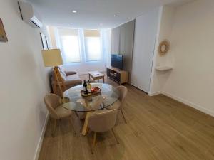 un soggiorno con tavolo e sedie in vetro di Apartamentos BONDELA a Madrid