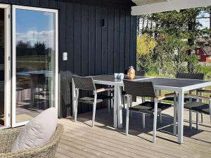 a patio with a table and chairs on a deck at 5 person holiday home in Rømø in Kongsmark