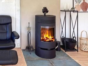 a fireplace in a living room with a fire at 6 person holiday home in Hals in Hals