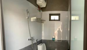 a bathroom with a shower and a toilet in it at Loop Trails Hostel in Làng Lap