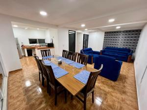 a dining room with a table and a blue couch at Casa Blanca Acolman Ideal for 10 people in Acolman de Netzahualcóyotl