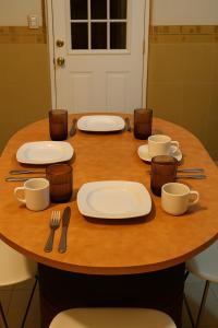 a wooden table with plates and utensils on it at Nova Stay Puebla in La Concepción +9 photos