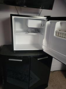 an empty refrigerator with its door open on a table at Morecambe Seaside Room in Heysham