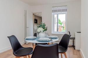 a dining room with a table and chairs at Stunning 3-Bedroom Home in Bletchley - Close to City Centre and Train Station - Free Private Parking - Fast Wi-Fi and Smart TV in Bletchley +6 photos