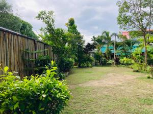 a yard with a fence and trees and grass at Lanta sky pool villa in Ko Lanta +4 photos