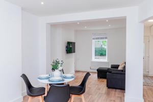 a living room with a table and chairs at Stunning 3-Bedroom Home in Bletchley - Close to City Centre and Train Station - Free Private Parking - Fast Wi-Fi and Smart TV in Bletchley