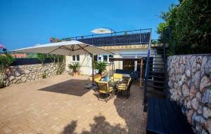 Barbat na RabuにあるHoliday Home Capella - Rab by Villas Guideの傘とテーブルと椅子のあるパティオ