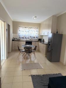 a kitchen with a table and a stainless steel refrigerator at Ocean View Cottage in Swakopmund