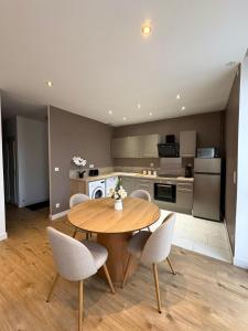 a kitchen and dining room with a wooden table and chairs at Nouveau au coeur de Troyes - Offre de lancement in Troyes +6 photos