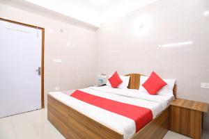 a bedroom with a large bed with red pillows at Hotel O Shree Raghuvar Dham in Vrindāvan