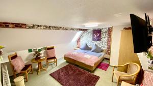 a bedroom with a bed and a table and chairs at Haus ZUR PINGE in Kurort Altenberg