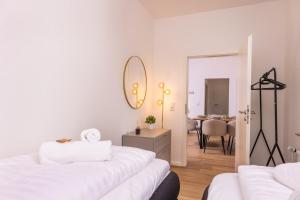 Dieses weiße Zimmer verfügt über 2 Betten und ein Esszimmer. in der Unterkunft NUIT Apartment - HBF, Zentral, Helios-Klinik, Messe Düsseldorf 19 km, NEU in Krefeld