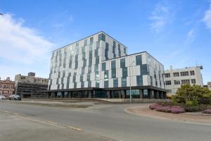 a large glass building on the corner of a street at Distinction Invercargill Hotel in Invercargill