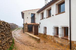 una casa blanca con una puerta en un camino de tierra en Masía La Parreta, en Villafranca del Cid
